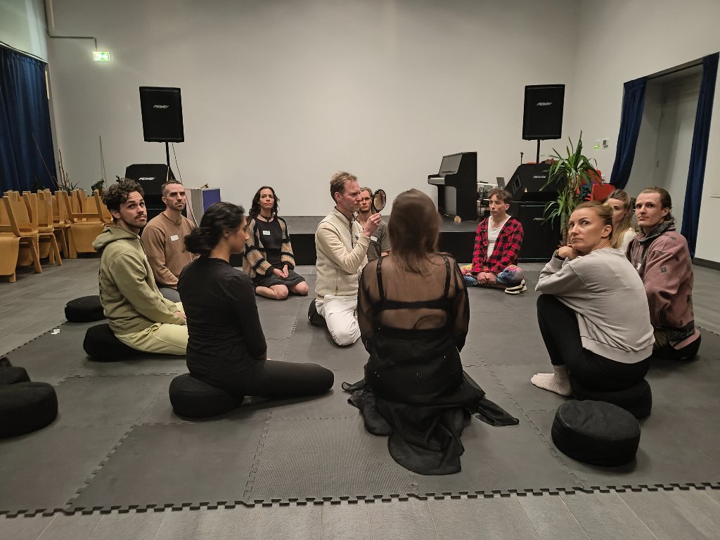 Participants seated in a circle during an indoor theatre workshop