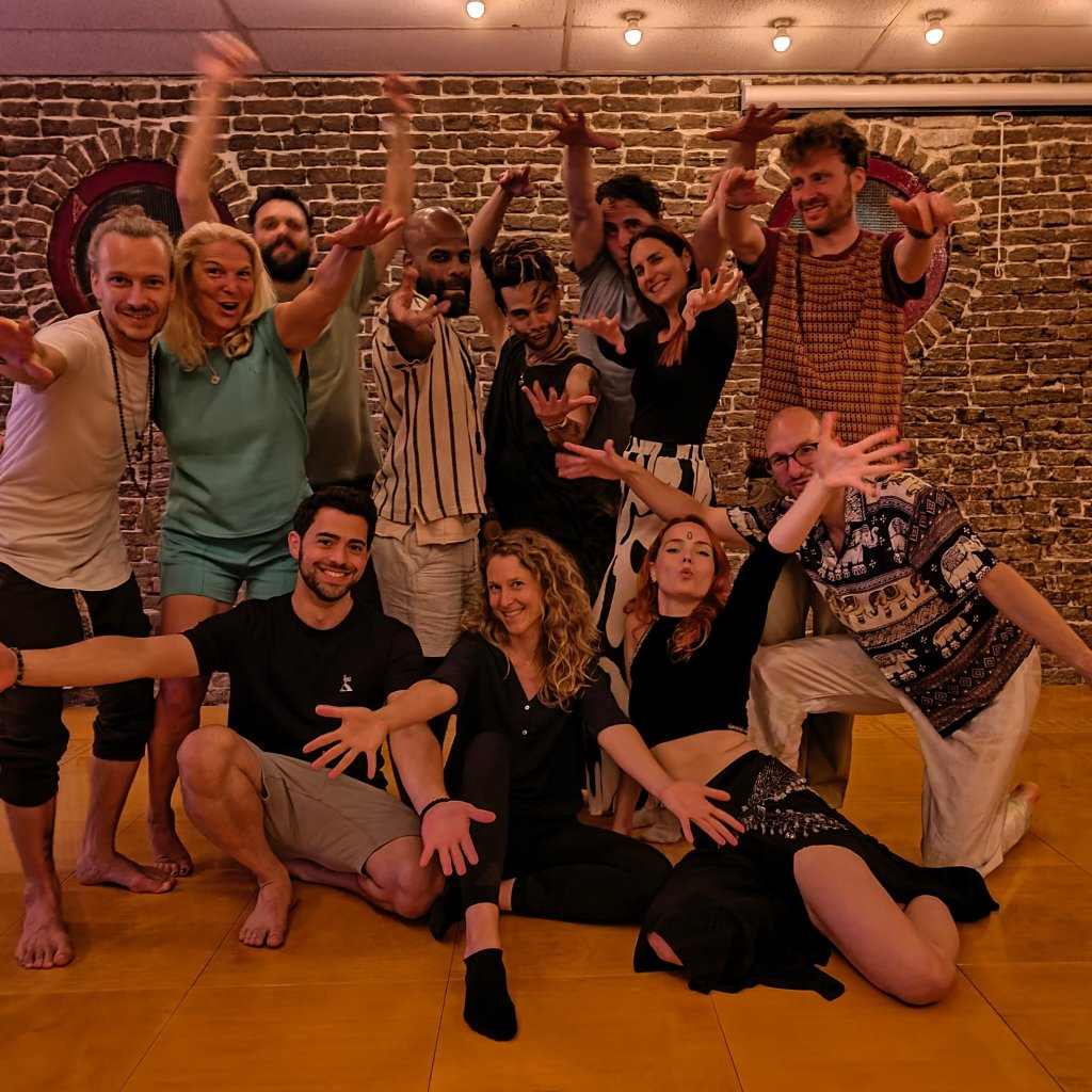 Playful group photo of workshop participants reaching toward the camera
